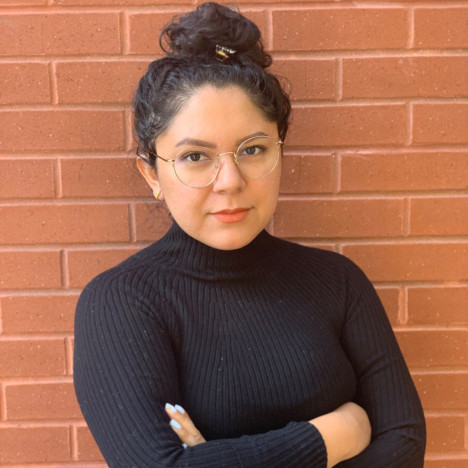 Constanza Salazar headshot photo with brick background.