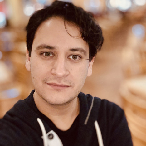 Rene G. Cepeda headshot photo with blurred bokeh background.