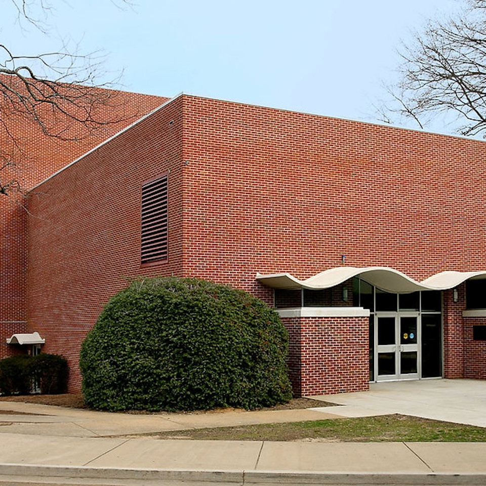 Meek Hall building at the University of Mississippi. It is a minimalist brick building with a stylized front entrance.